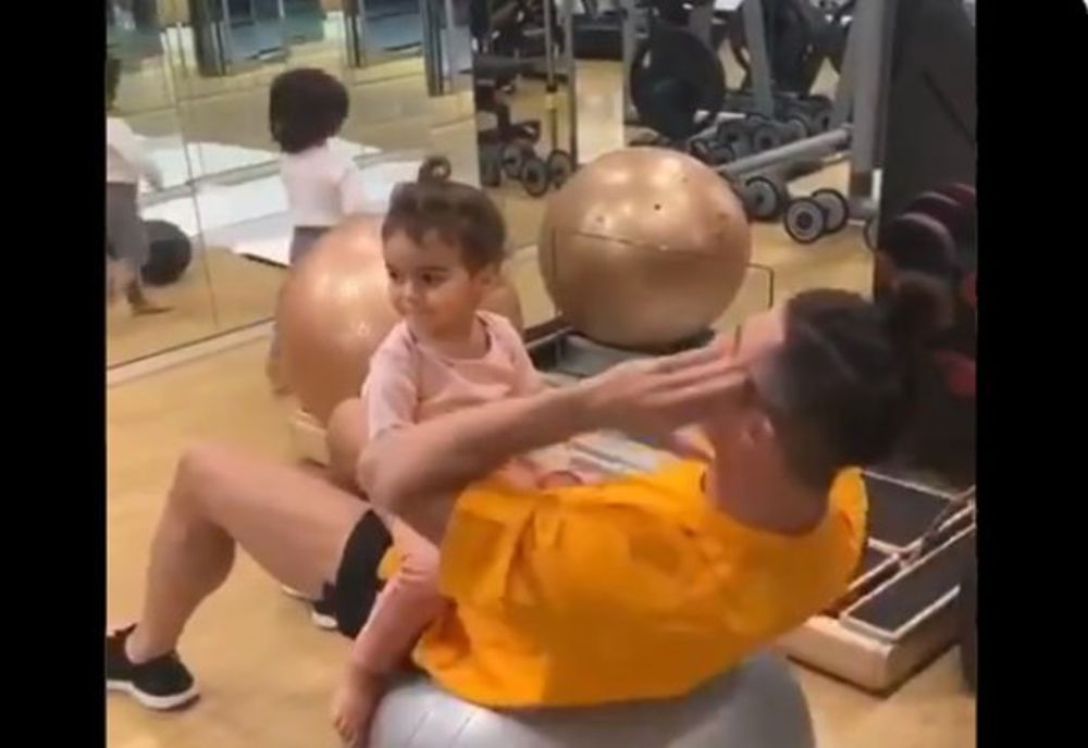 Cristiano Ronaldo face exerciții pentru abdomen în timp ce fetița sa stă asezată pe el